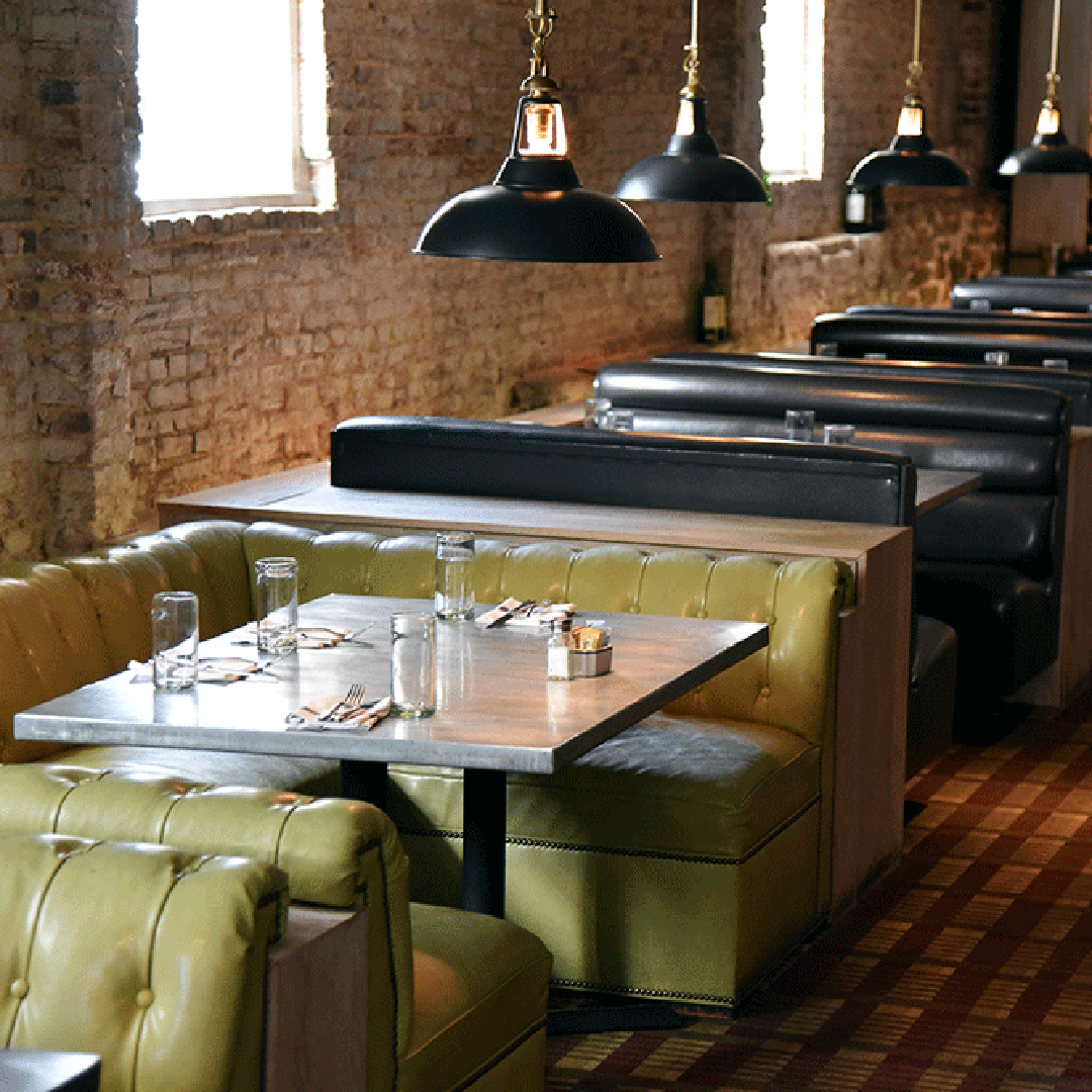 Row of green and black booths with hanging light fixtures