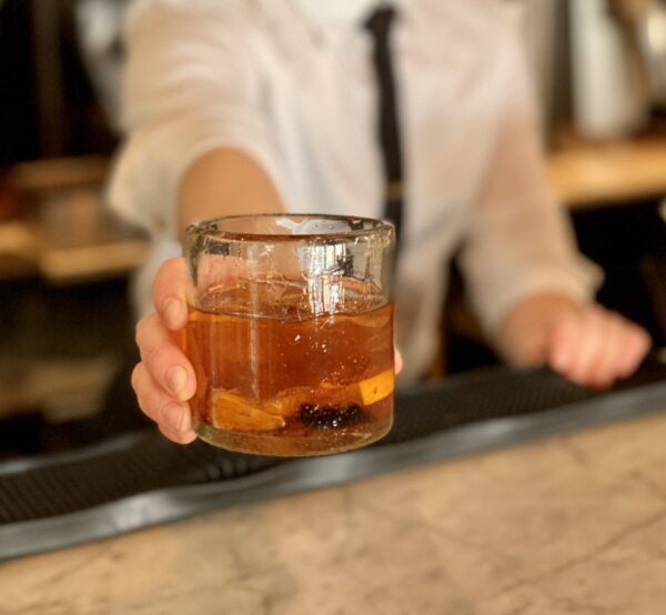 Bartender pouring whiskey into a rocks glass